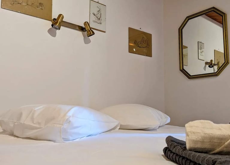 Un lit avec des dessins de nue au dessus et un miroir sur le côté