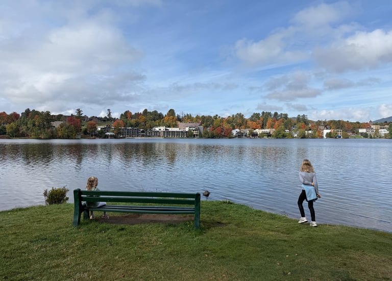 Two girls admire the landscape of Mirror Lake in Lake Placid in autumn