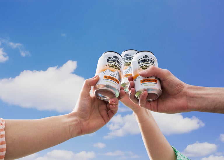 Product video campaign photography - two people holding cans of woodstock in their hands