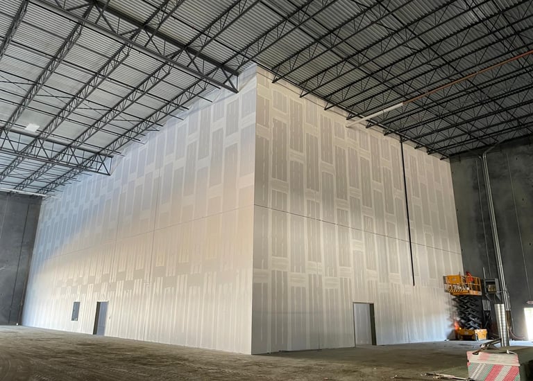 a large white wall where you can see that work is being done smoothing the walls of a commercial job
