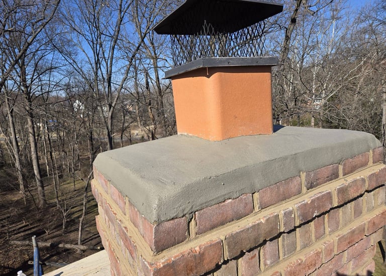 A newly installed concrete chimney crown and metal cap on a brick chimney by Roslyn Chimney