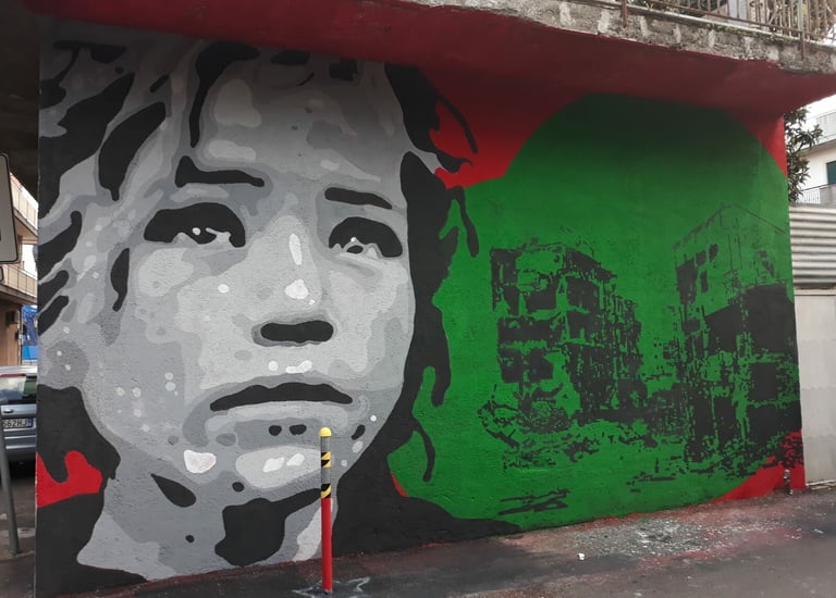 Social-themed mural with female face and ruined buildings, urban art by Poliops.