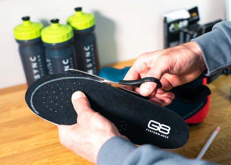 A bike fitter trimming some insoles