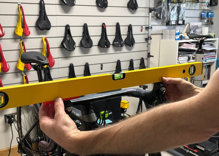 A bike fitter checking the handlebars are level