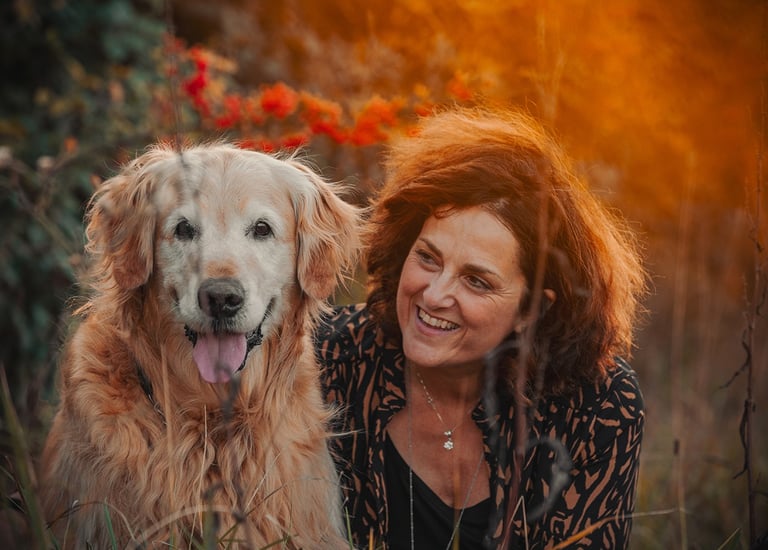 cane e padrona in un campo di fiori rossi al tramonto