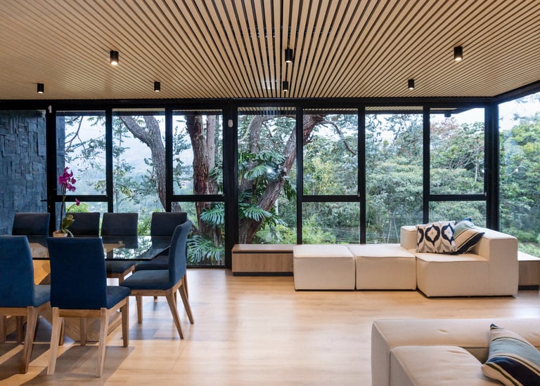 Interior moderno con ventanales de piso a techo y vista al jardín, iluminación cálida