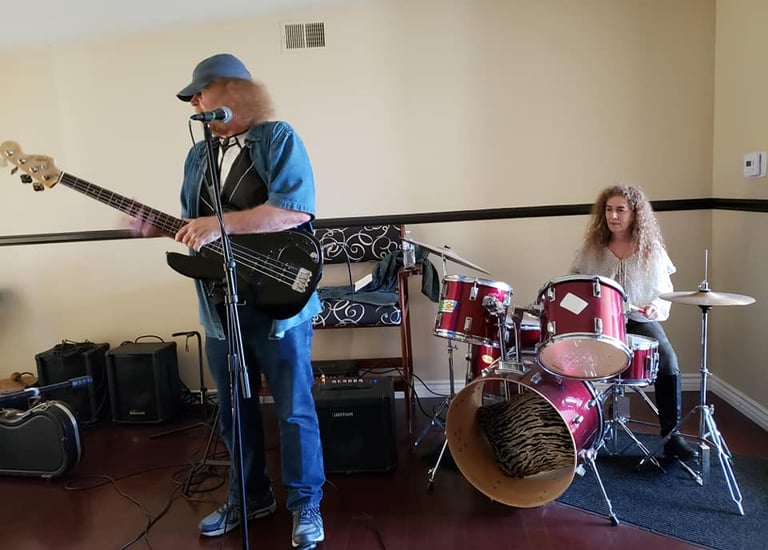 a man playing guitar in a room with a woman