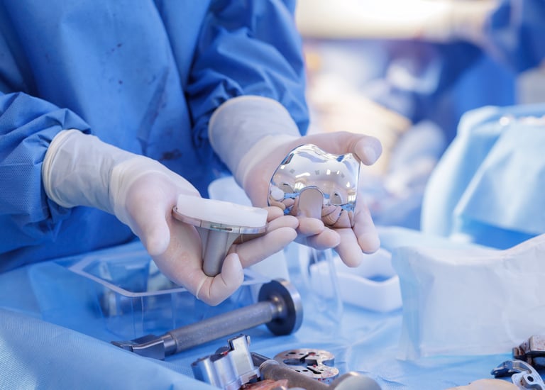 medical technical inspecting a set of orthopedic knee implants.