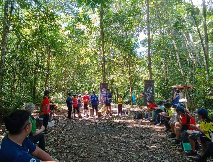 a group of people sitting on benches in a forest