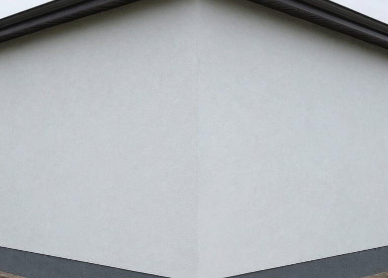 Close-up of professional painter applying smooth exterior wall paint.