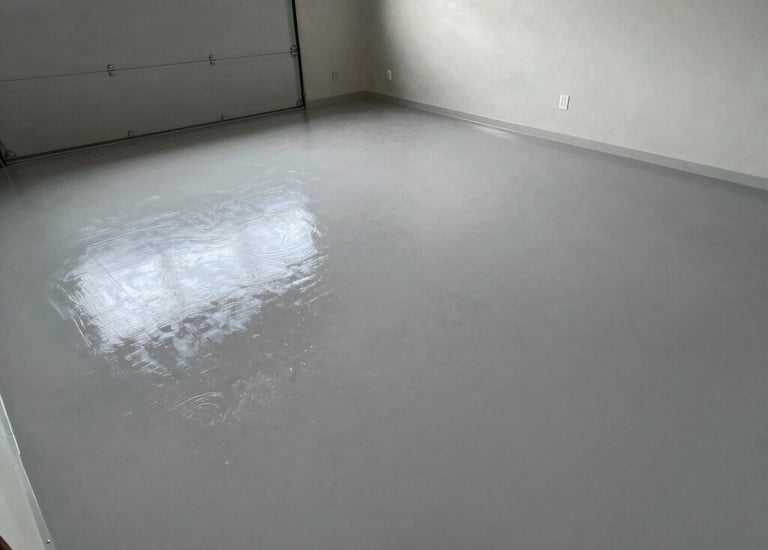 Freshly applied light grey epoxy garage floor coating with a glossy reflective finish.