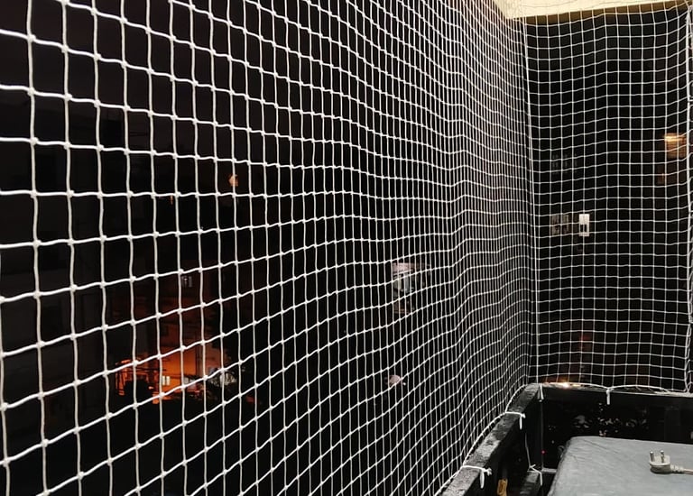 Wide view of a residential building in Vile Parle with multiple balconies fitted with safety nets.