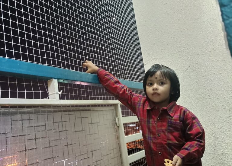 Close-up of a sturdy balcony safety net protecting a child playing on the balcony.