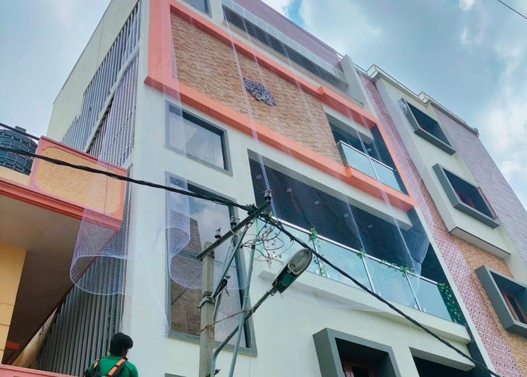Evening view of a residential building with pigeon nets glowing softly under warm lights.