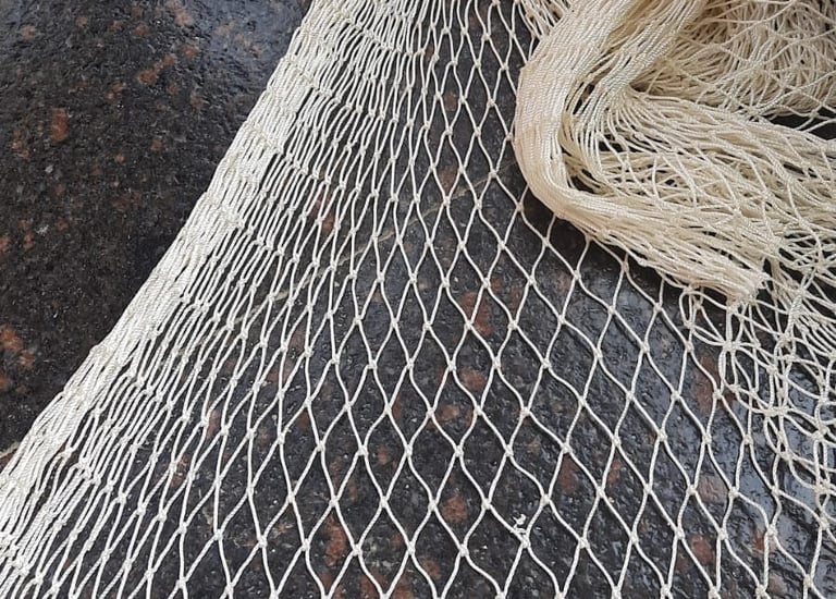 Photograph of completed pigeon net installation wrapping the entire warehouse perimeter.