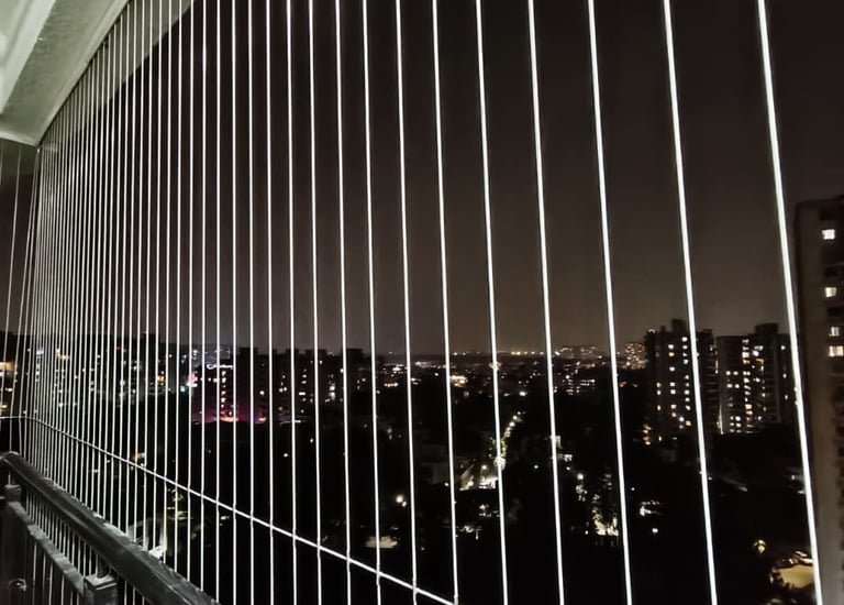 Invisible grills fitted seamlessly on a modern balcony, blending with the architecture.