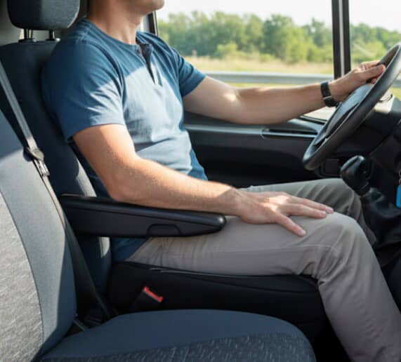Driver seated comfortably using a padded car armrest for added support while driving
