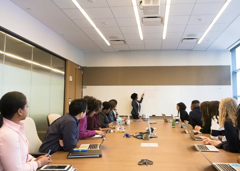 A professional trainer explaining Jira test management to a focused group in a modern conference room.