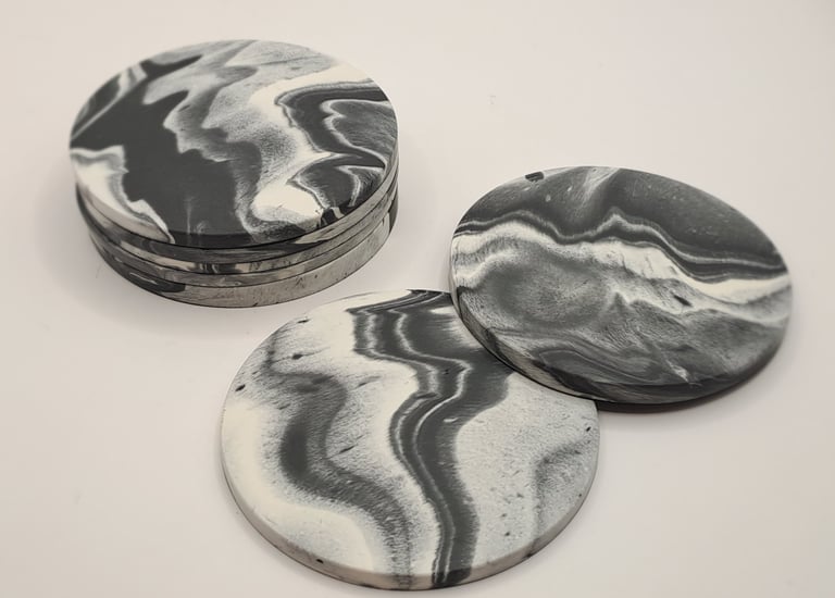 Handmade black and white marbled gypsum coasters in a stack.