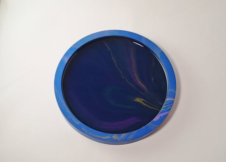 Handmade round dark blue tray with a dark galaxy swirl and northern lights pattern.