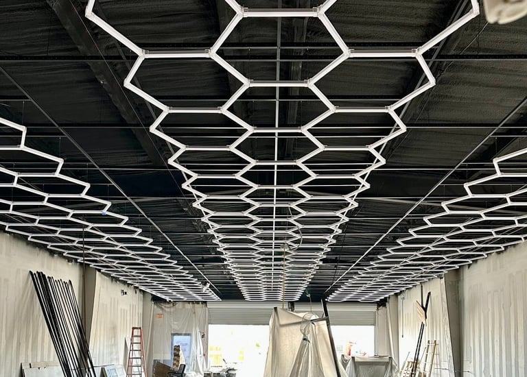 Custom honeycomb LED lighting installation over black industrial exposed ceiling