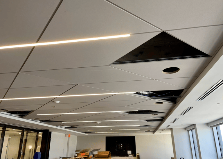Modern geometric acoustic ceilings with linear LED lighting in Downtown Orlando.