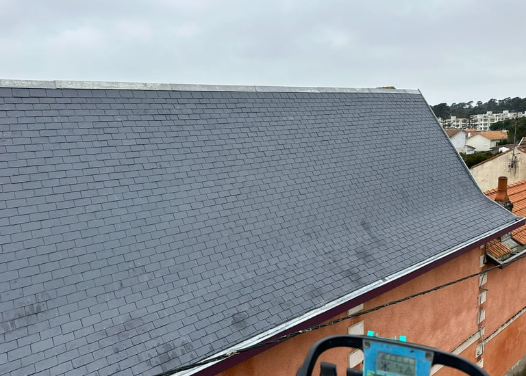 Installation professionnelle de toiture en ardoise sur un bâtiment résidentiel avec des bardeaux gri