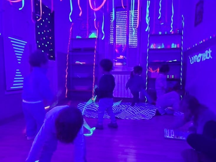 Aula sensorial amb llum fosca, amb materials tàctils i sensorials per estimular els infants.