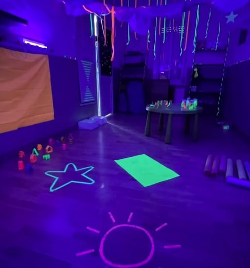 Aula sensorial amb llum fosca, amb racons i jocs per l’experimentació i el joc sensorial.