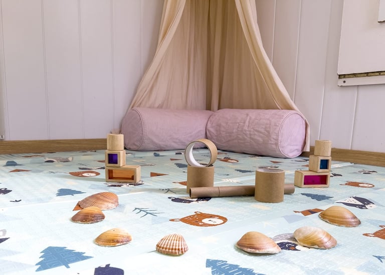 Racó de relax amb coixins i materials sensorials per a moments de calma i benestar dels infants.