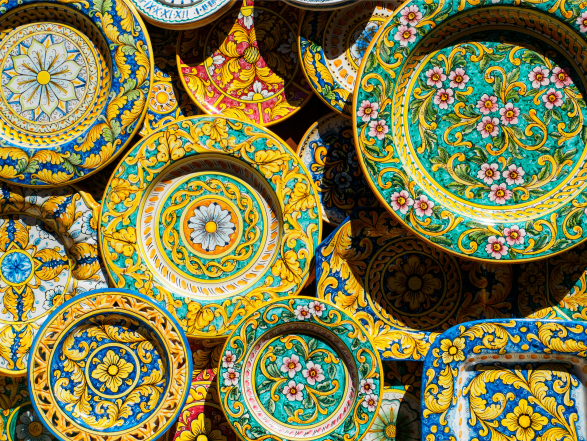 Hand-painted Italian maiolica ceramic plates with colorful Mediterranean floral and geometric patterns.