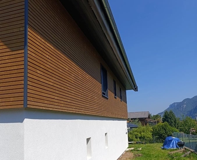 a house with a tent pitched in the grass