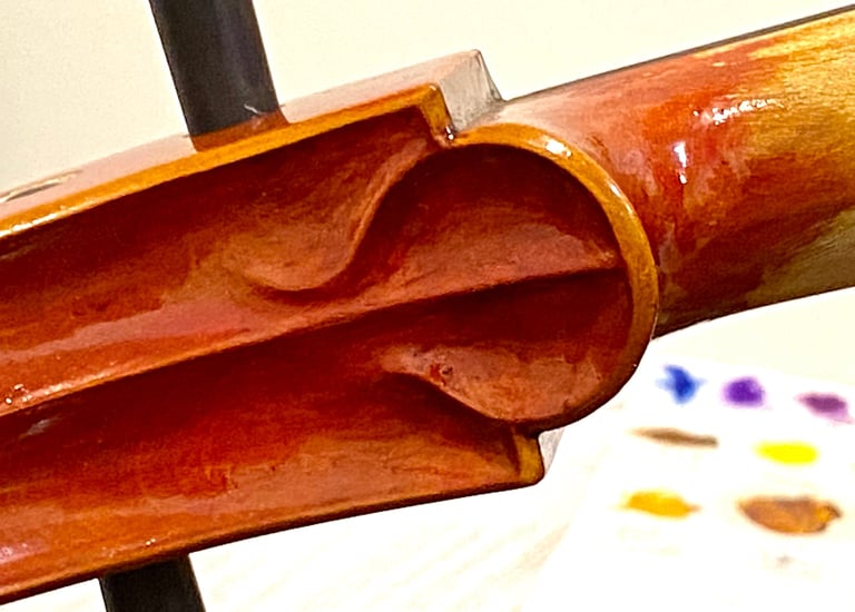 The 2024 cello "chin at the lower end of the scroll has creative, individualized detail.