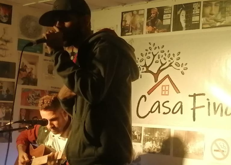 Presentación en vivo con un cantante y un guitarrista acústico en un escenario intimo