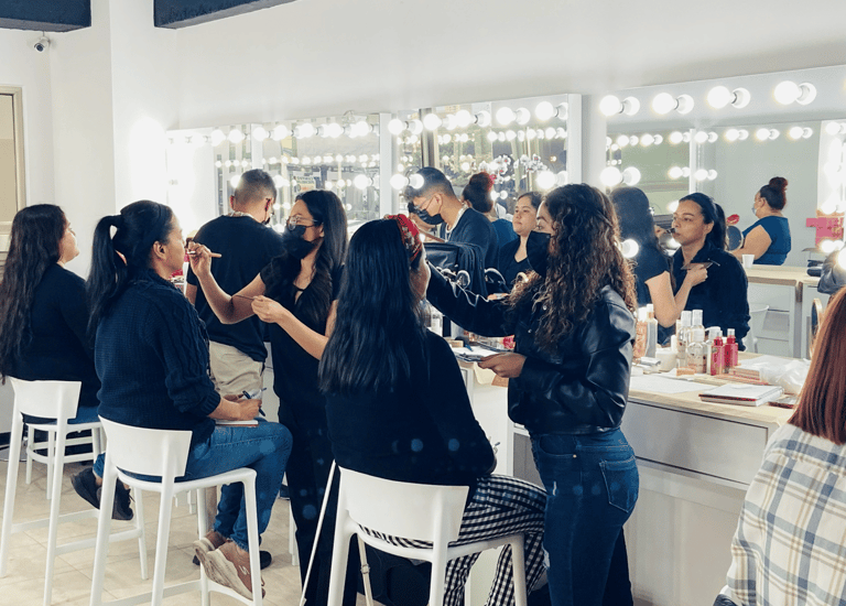 Maquilladores profesionales que aplican cosméticos a los clientes en un estudio luminoso con espejos