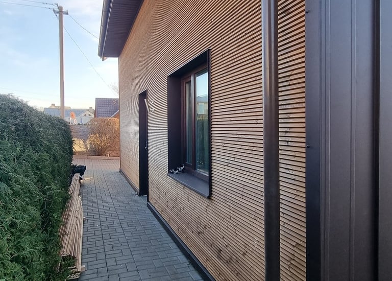 a house with a wooden siding and a brick wall