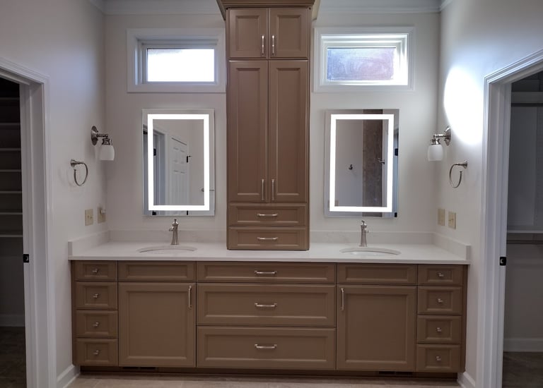 Modern master bathroom double vanity with taupe cabinets, marble countertops, and LED lighted mirrors.