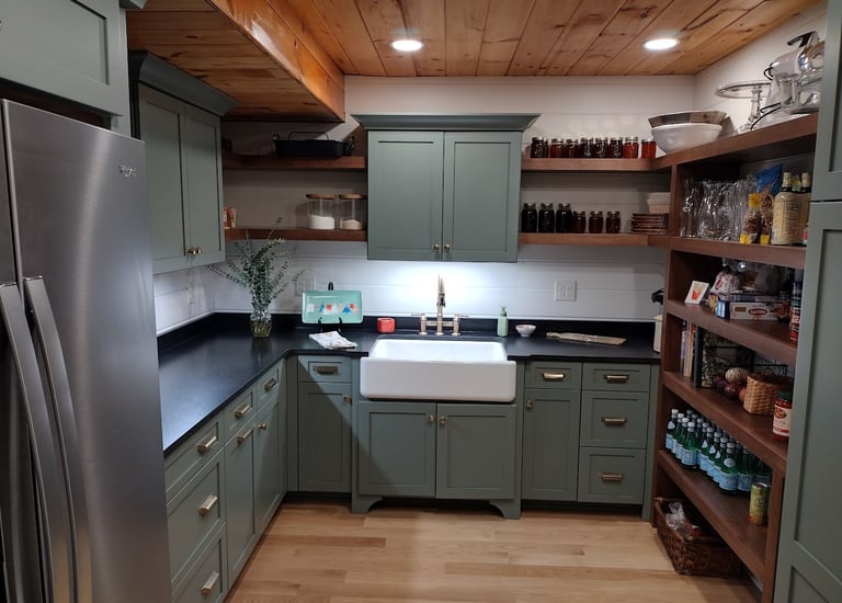 Modern rustic kitchen with sage green cabinets, farmhouse sink, and open wood shelving.
