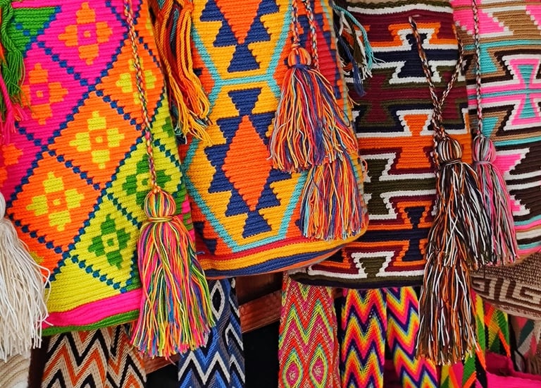 Sacs à dos Wayuu colorés tissés à la main, avec des motifs géométriques et des pompons, suspendus da