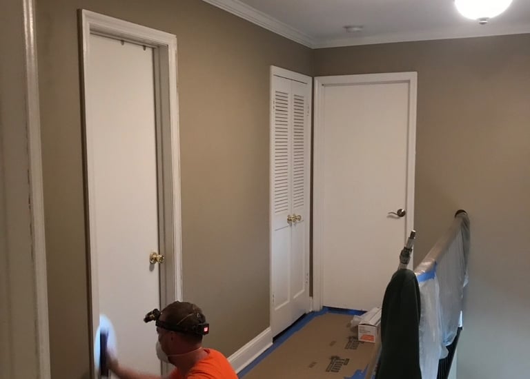 a man is painting a wall in a room