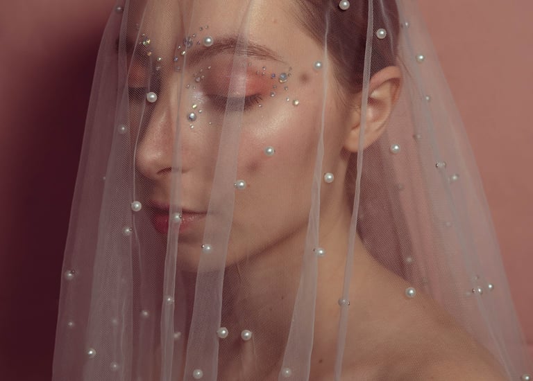 Photo artistique d'une femme sous un voile avec des strass sur le visage