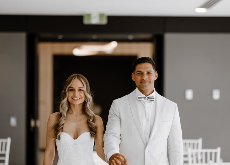 a bride and groom holding hands and smiling