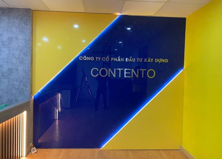 vách lễ tân bằng kính cường lực sơn mầu, trang trí đèn led tạo hiệu ứng đẹp, logo inox dán nổi