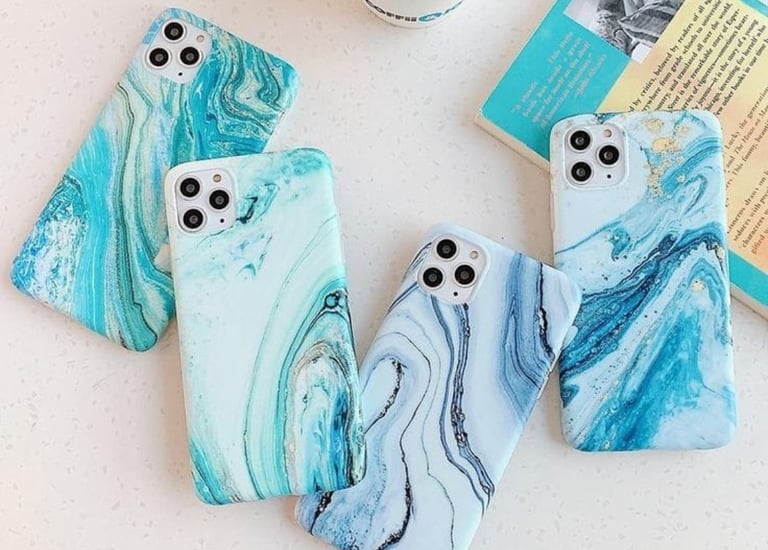 a group of three cell phones with a coffee cup