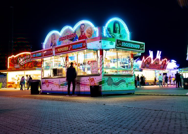 festival sockervadd kiosk neon belysning natt