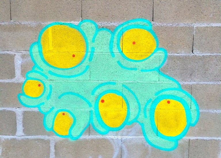 "Street art représentant un personnage turquoise couvert de nombreux yeux, style urbain et coloré su
