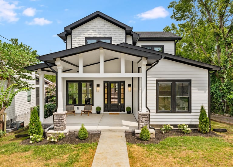 a white house with a black roof and a white door
