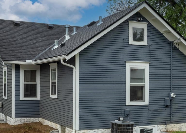 a house with a blue house with a black roof