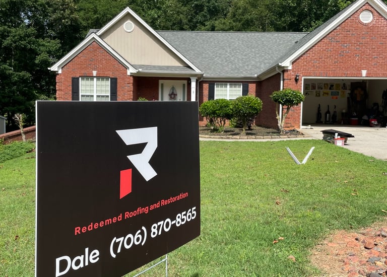 picture of dale sign from redeemed roofing in front of house