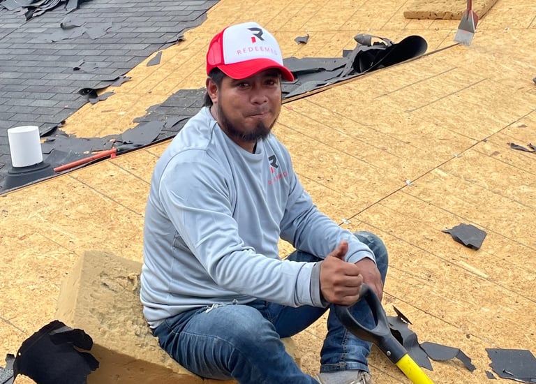 Worker on the damaged roof redeemed-roofing